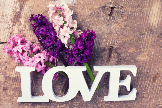 Fresh spring hyacinths flowers  and word love on vintage  wooden