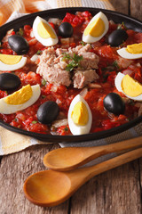 Arabic cuisine: tuna salad with vegetables and eggs close-up. Vertical
