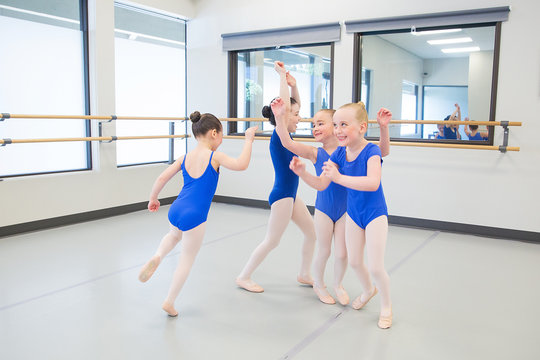 group of young ballet dancers playing in studio