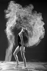 Obraz na płótnie Canvas Black and white portrait of young dancer with white powder flipp