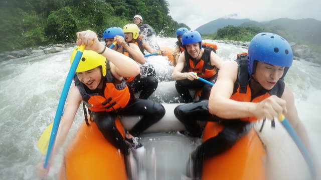 Experience the thrill of whitewater rafting as tourists scream and yell,capturing high quality footage with audio from an onboard camera,amidst the exhilarating impact of a massive wave.