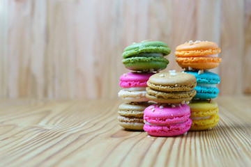A lot of french colorful macarons on a woody floor, copy space
