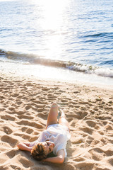 Happy woman resting on sand