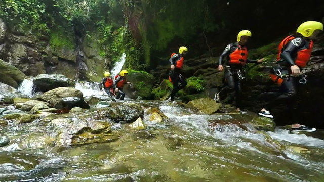 Experience the breathtaking beauty of Llanganates National Park as a group of tourists leisurely explores the stunning Ecuadorian canyon in captivating slow motion footage captured by a static camera.