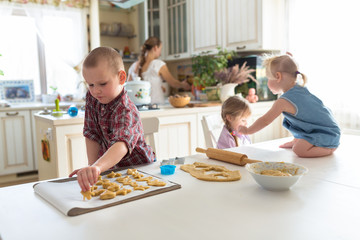 children with her mother preparing cookies,  large family. casua