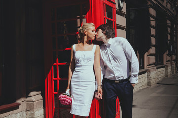 Bride and groom kissing on background of the phone booth. Tourism, travel people concept - happy senior couple over london city street in england - 106466696