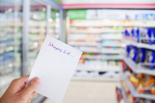 hand hold shopping list paper with convenience store