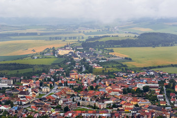 Obraz premium Little european willage, houses in fields, cloudy sky, mountains landscape