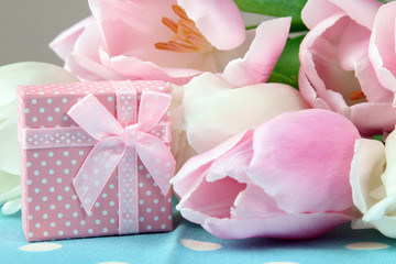 beautiful pink tulips and white laid out on the fabric in polka dot small box