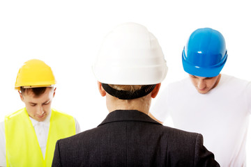 Female engineer talking with two builders