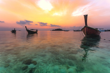 Anchored boats clear sea, coral underwater, twilight sunrise