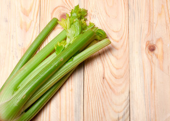 fresh green celery in coner on wooden background