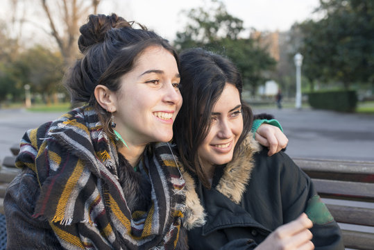 Two smiling beautiful woman friends in the park.
