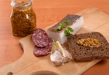 Sliced lard on wooden table with onion and knife horizontal