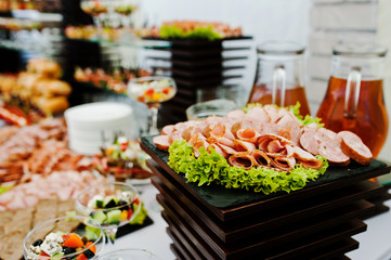 Buffet table of reception with burgers, cold snacks, meat and sa
