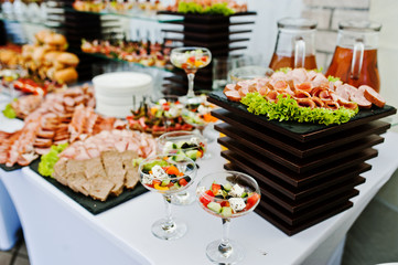 Buffet table of reception with burgers, cold snacks, meat and sa