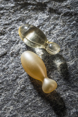 Gel capsules on a stone background