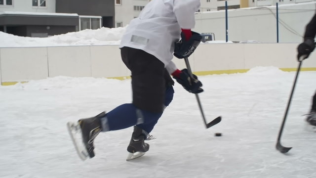Ice hockey forward carrying a puck, getting past a defenseman and taking an unsuccessful shot on a goalie
