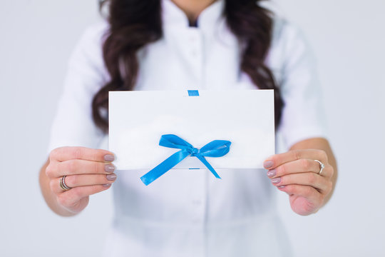 Close up of doctor holding blank white gift card