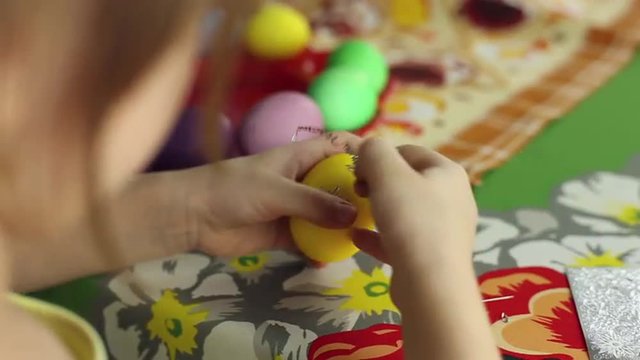 Preparation of Easter eggs, the feast of the passover, girl sticks decorative stickers on the Easter eggs
