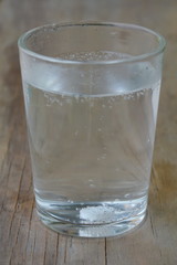 antacids in water glass on wooden table