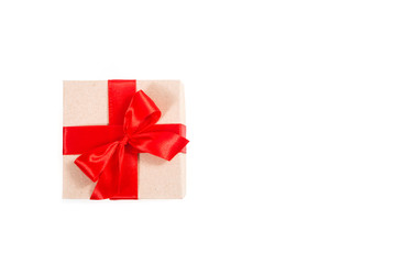 Gift box wrapped in recycled paper with red ribbon 