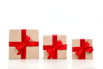 Gift box wrapped in recycled paper with red ribbon 