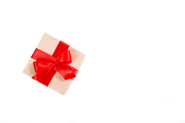 Gift box wrapped in recycled paper with red ribbon 