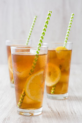 refreshing iced tea with lemon on white wood
