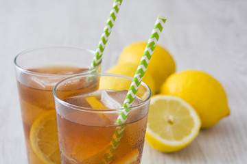 refreshing iced tea with lemon on white wood