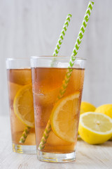 refreshing iced tea with lemon on white wood