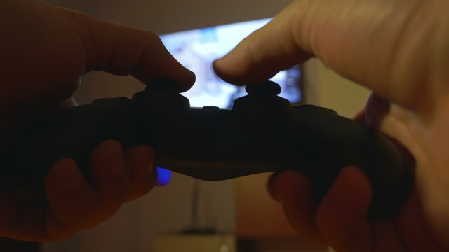 Close-up of man hands playing console games with a controller