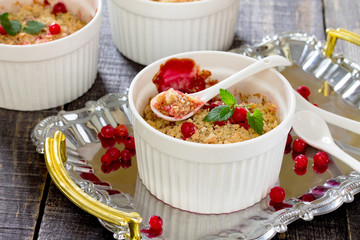 Dessert crumble with red currants on a dark wooden table