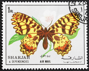 Fototapeta na wymiar GROOTEBROEK ,THE NETHERLANDS - MARCH 8,2016 : A stamp printed in Sharjah shows butterfly, circa 1972