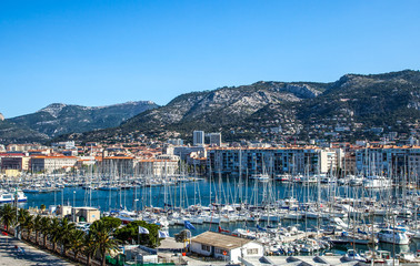 Toulon, France, the harbor crowded of boats with the city in the background.