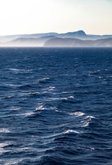 Naklejka premium France, the misty Toulon coast seen from a rough open sea.