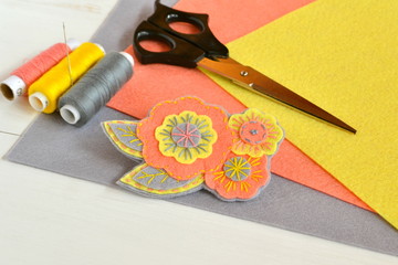 Obraz premium Floral felt brooch, handmade crafts. Felt sheets, scissors, thread, needle - sewing set