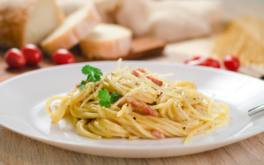 Pasta Carbonara with bacon on a white plate, close-up, side view
