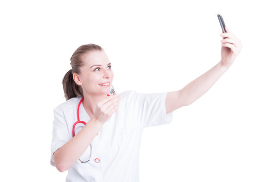Beautiful woman doctor taking a selfie using phone