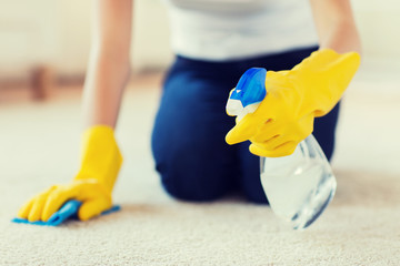 close up of woman with cloth cleaning carpet