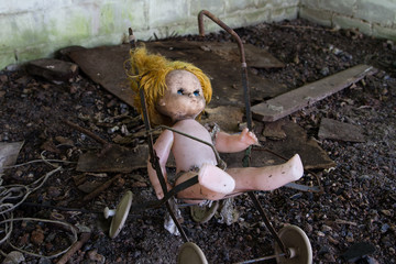 UKRAINE. Chernobyl Exclusion Zone. - 2016.03.19. Old abandoned doll on a broken toy stroller
