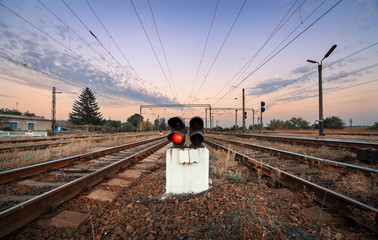 Railway station and traffic light at colorful sunset in vintage style. Railroad. 