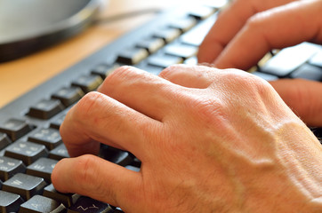 Close-up of typing male hands on keyboard