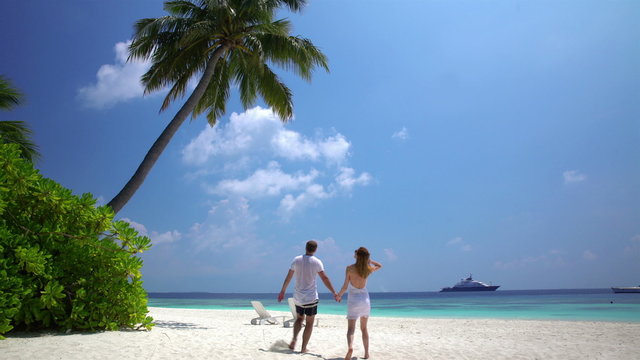 A loving couple enjoying vacation on a tropical beach.