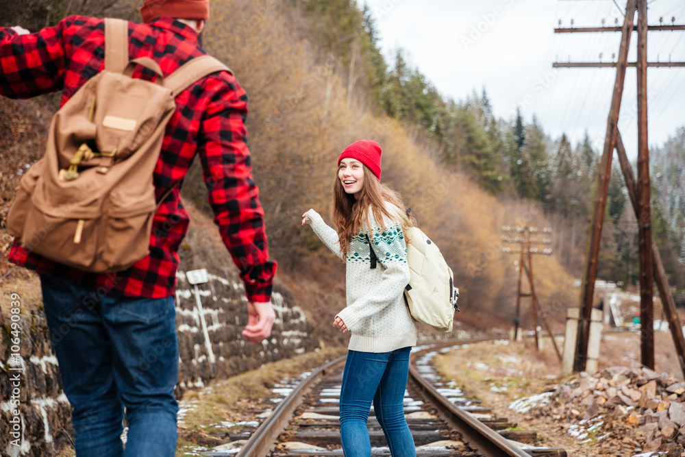 Wall mural Couple talking and walking on railroad together