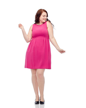 happy young plus size woman dancing in pink dress