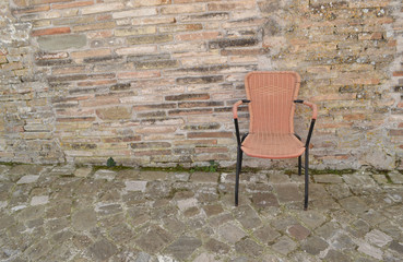 Stuhl vor Natursteinwand