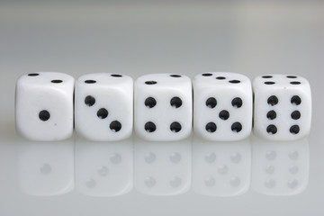 Dice. Playing cubes. Throwing the dice during the game. White cubes arranged in a row. On a white background. There is room for text.