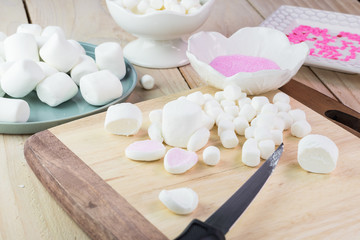 Cut marshmallows for easter bunny cake decoration.