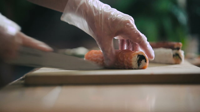 Cutting sushi roll into portions